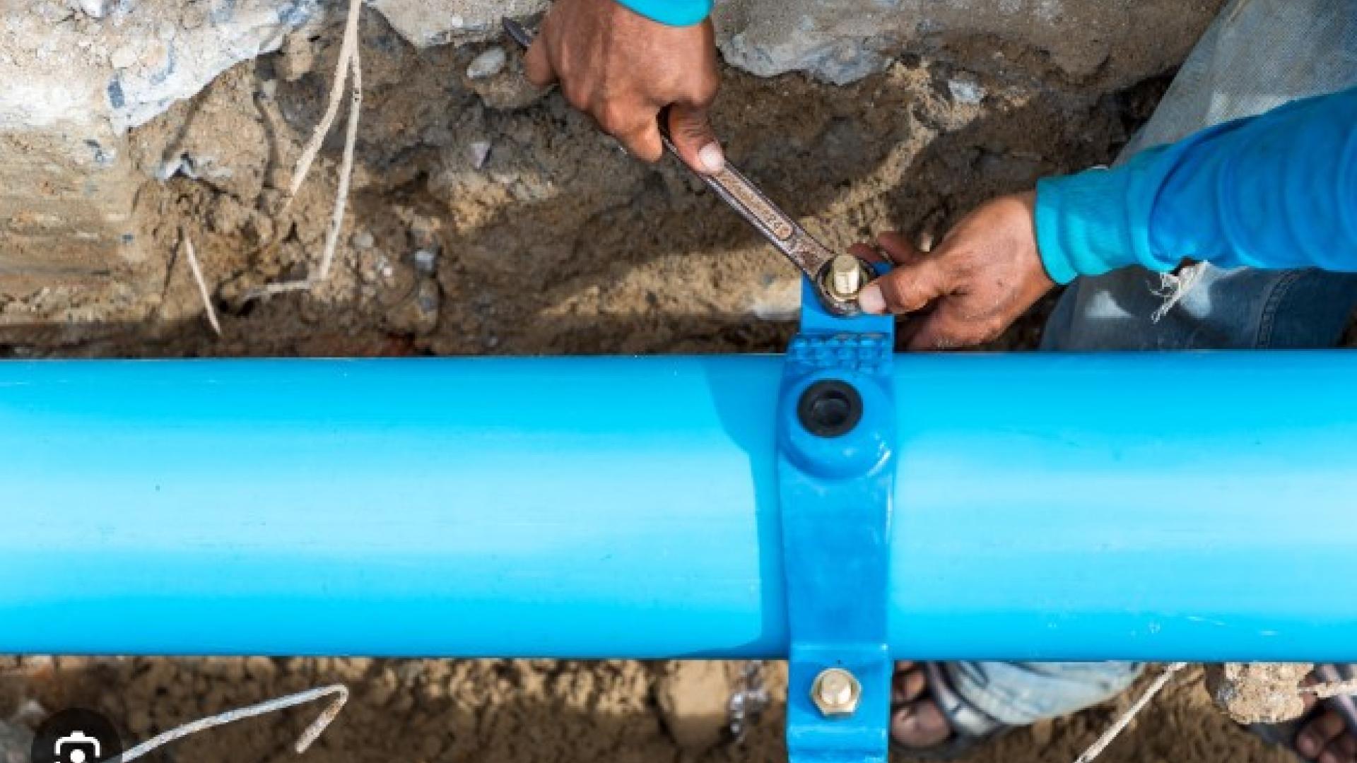 Hands repairing blue water pipe